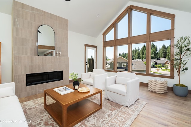 11996 N Rocking R, Hayden, ID 83835 - living area featuring a tiled fireplace, wood finished floors, and high vaulted ceiling