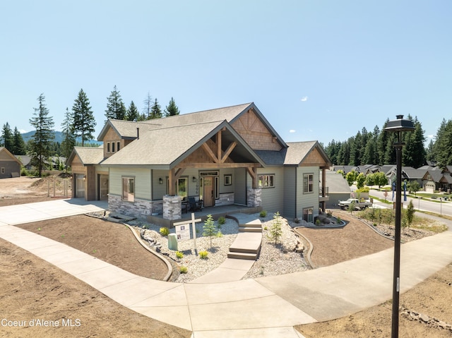 11996 N Rocking R, Hayden, ID 83835 - craftsman house with stone siding, covered porch, concrete driveway, and roof with shingles