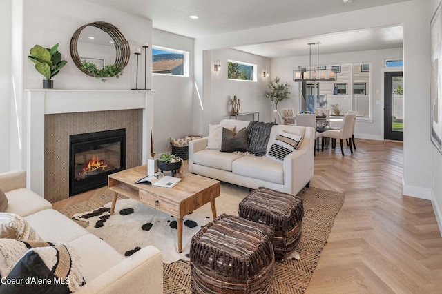 living room featuring light parquet floors and a tile fireplace