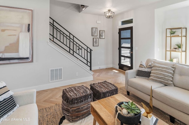 living room featuring light parquet flooring and a chandelier