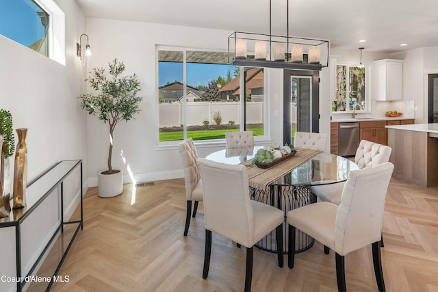 dining room with a wealth of natural light, sink, and light parquet flooring