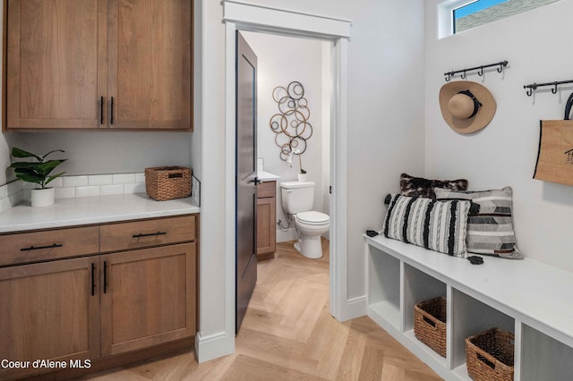 bathroom featuring parquet flooring and toilet