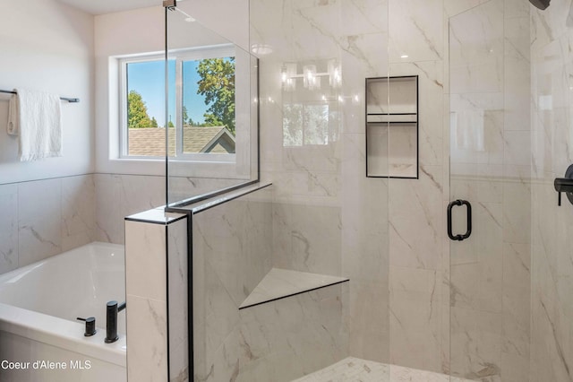 bathroom with tile walls and separate shower and tub