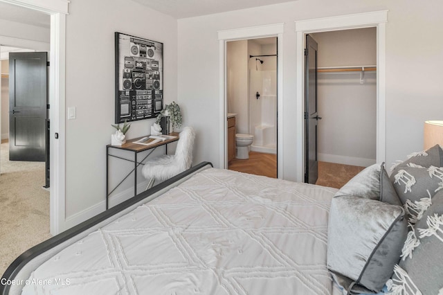 bedroom featuring a closet, carpet floors, connected bathroom, and a walk in closet