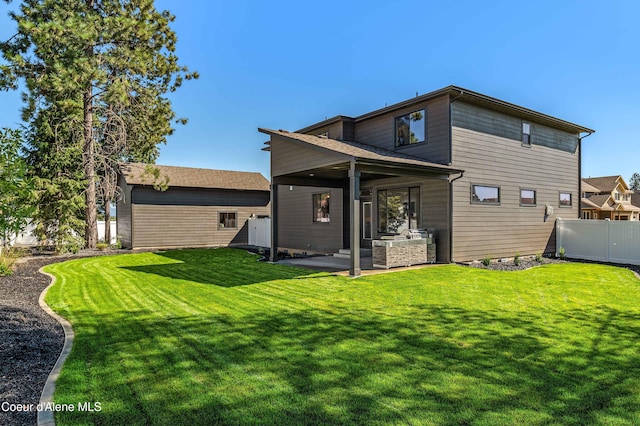 back of property with a yard and a patio area