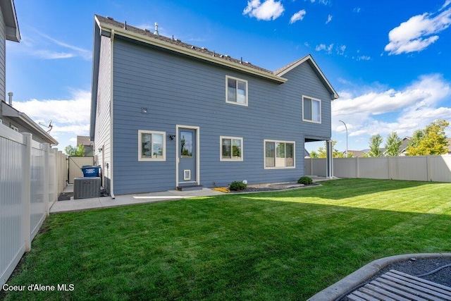 rear view of property featuring a yard and cooling unit