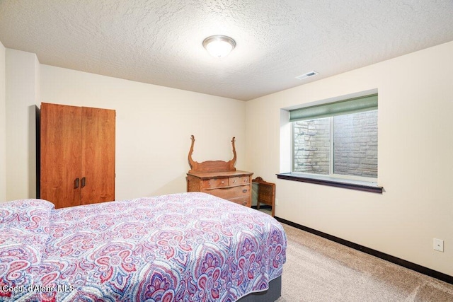 bedroom featuring carpet and a textured ceiling