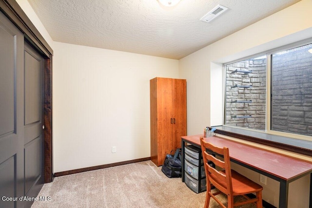 office featuring light carpet and a textured ceiling