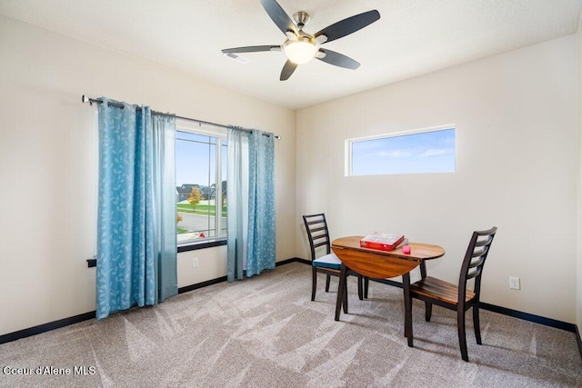 carpeted dining area with ceiling fan and a wealth of natural light