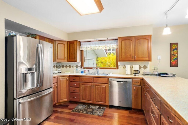 kitchen with light countertops, appliances with stainless steel finishes, dark wood-style floors, and a sink