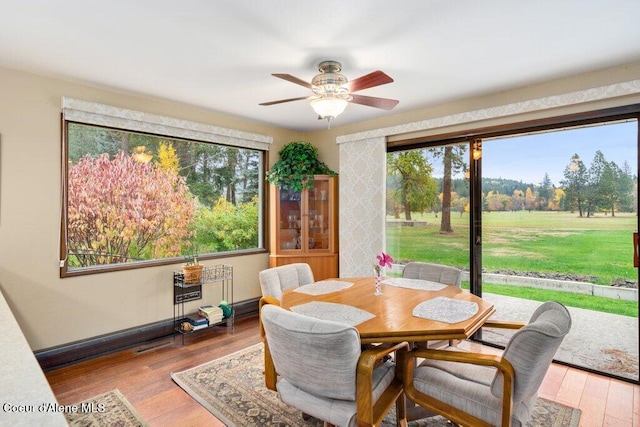 dining space with light wood finished floors and ceiling fan