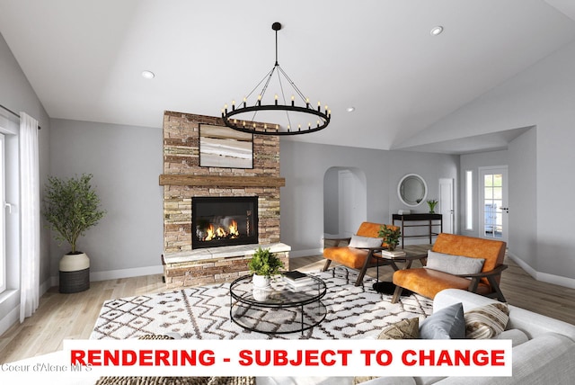 living room featuring lofted ceiling, a stone fireplace, and light hardwood / wood-style floors