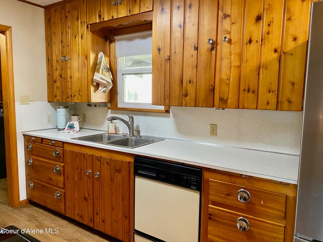 kitchen featuring dishwasher, light hardwood / wood-style flooring, stainless steel refrigerator, and sink