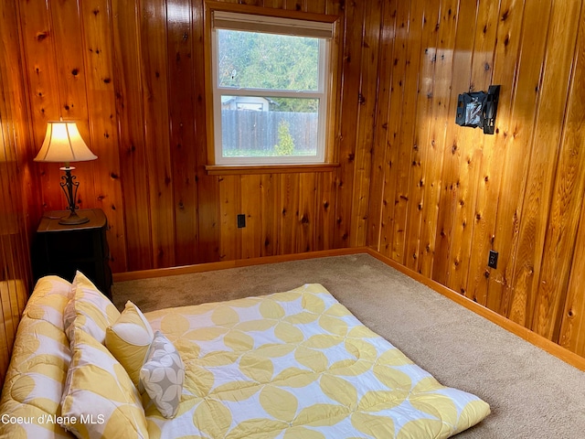 bedroom featuring wood walls and carpet