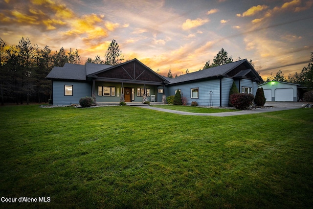 view of front of property with a yard, covered porch, an outdoor structure, and a garage