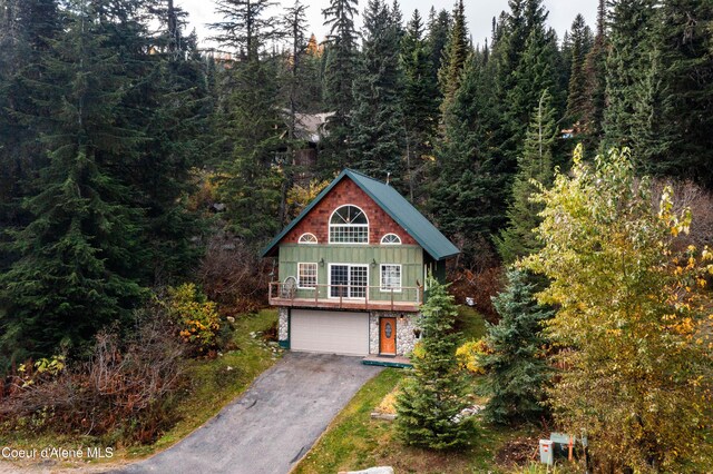 296 Ullr Dr, Sandpoint, ID 83864 - exterior space featuring a garage, driveway, and a wooded view