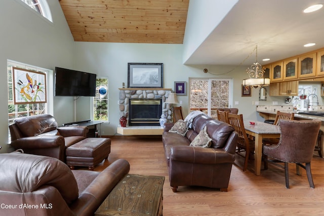 296 Ullr Dr, Sandpoint, ID 83864 - living area with light wood finished floors, high vaulted ceiling, a stone fireplace, recessed lighting, and wood ceiling