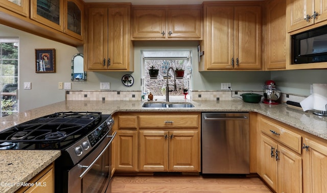 296 Ullr Dr, Sandpoint, ID 83864 - kitchen with a sink, light stone counters, stainless steel appliances, and light wood-style flooring