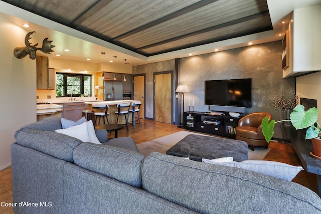 living area featuring a raised ceiling and recessed lighting