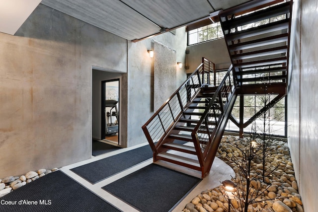 staircase with a high ceiling and concrete floors