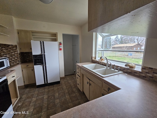 kitchen with white refrigerator with ice dispenser, decorative backsplash, electric range, and sink