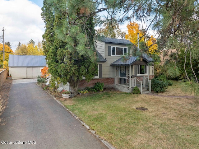 view of front of house with a front yard, an outdoor structure, and a garage