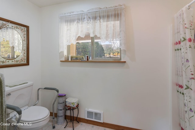 bathroom with toilet, walk in shower, and tile patterned flooring