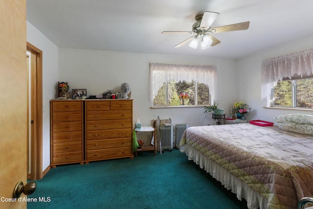 carpeted bedroom featuring multiple windows, radiator heating unit, and ceiling fan