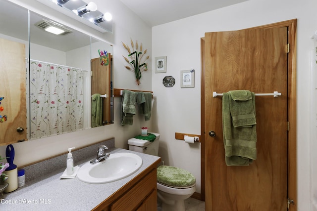 bathroom with toilet, walk in shower, and vanity