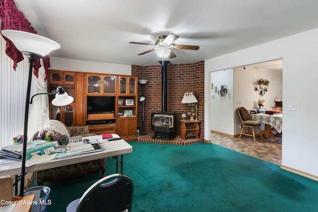 office space featuring a wood stove and ceiling fan