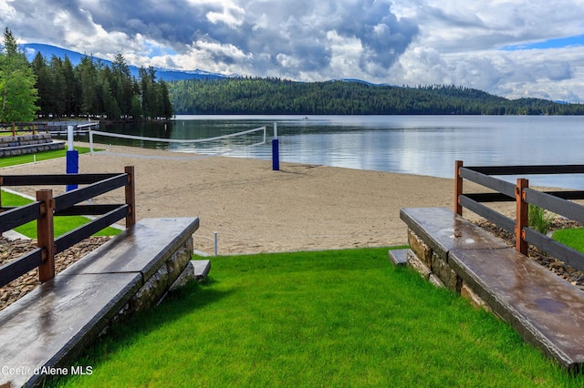 view of property's community with a water and mountain view and a yard