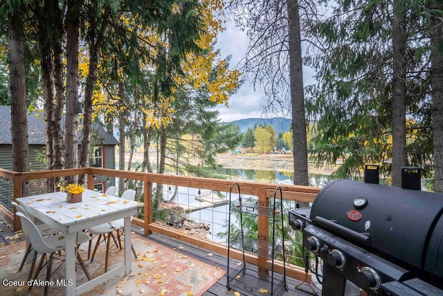 exterior space with a water and mountain view and a grill