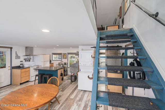 stairs featuring stacked washer / dryer and hardwood / wood-style floors