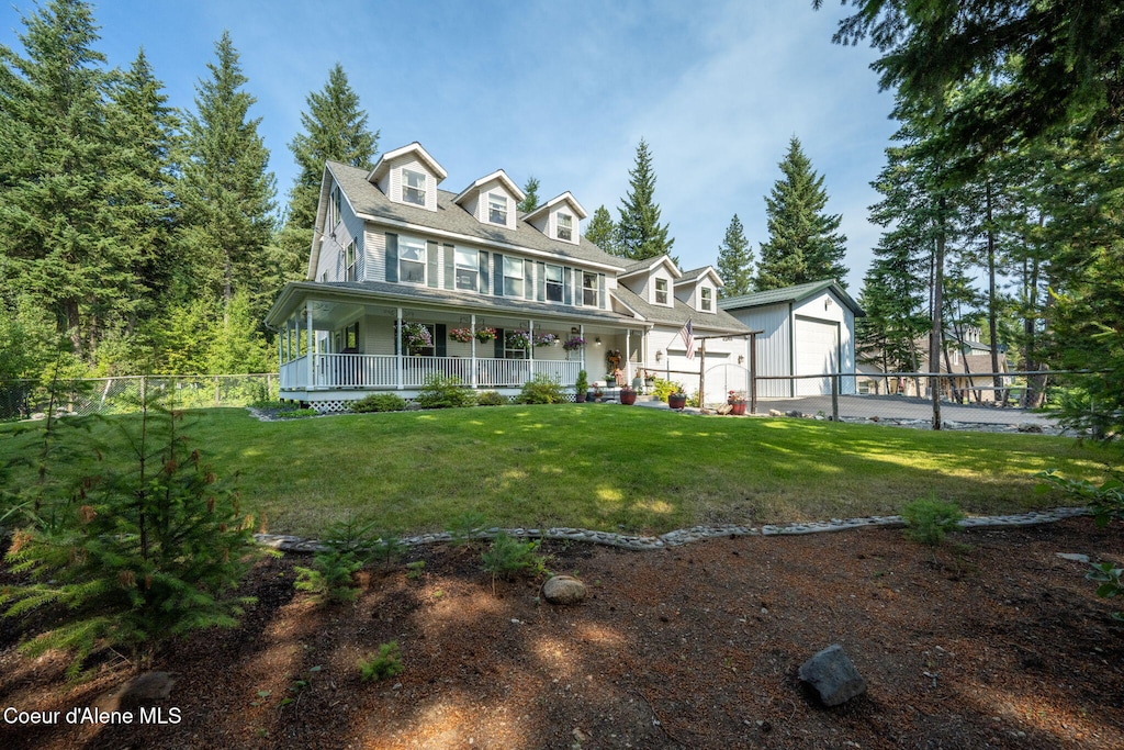 view of front of house with an outbuilding, a porch, a front lawn, and a garage