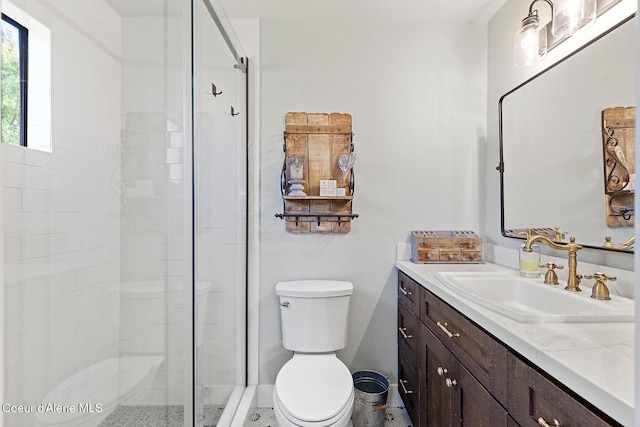 bathroom with a shower with door, vanity, and toilet