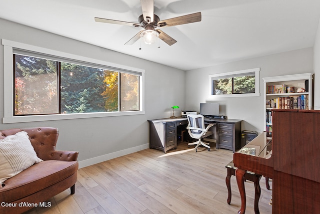 home office with light hardwood / wood-style floors and ceiling fan