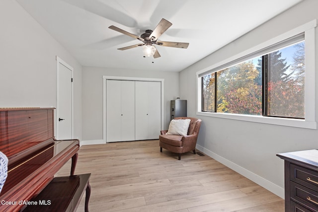 living area with light wood-type flooring and ceiling fan