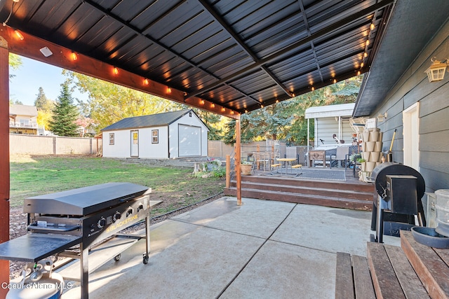 view of patio with a wooden deck, a storage unit, and a grill