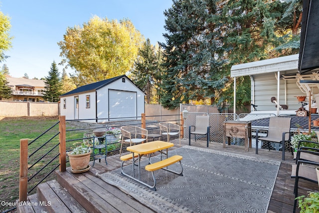 wooden deck featuring a lawn, a garage, and an outdoor structure