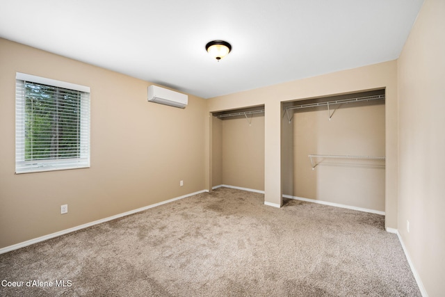 unfurnished bedroom featuring a wall mounted AC, light colored carpet, and two closets