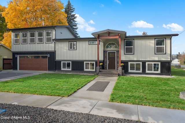 raised ranch featuring a garage and a front yard