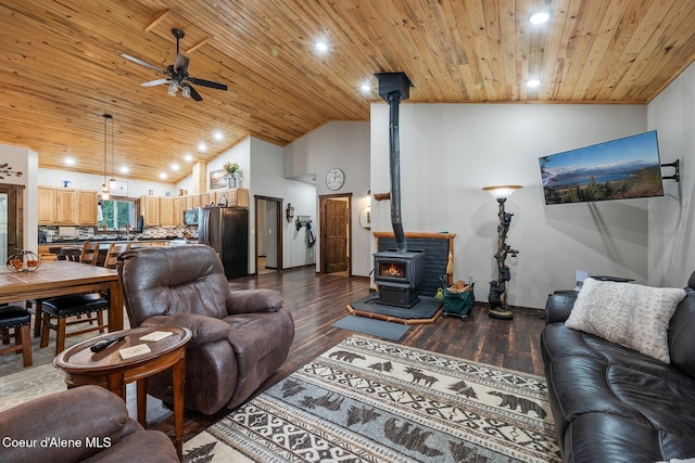 living room featuring wood ceiling, hardwood / wood-style floors, ceiling fan, high vaulted ceiling, and a wood stove