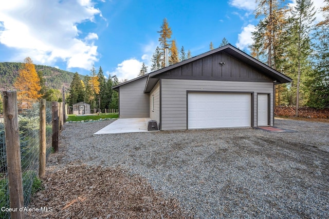 648 Curley Creek Rd, Moyie Springs, ID 83845 - garage featuring a storage shed, a mountain view, and fence