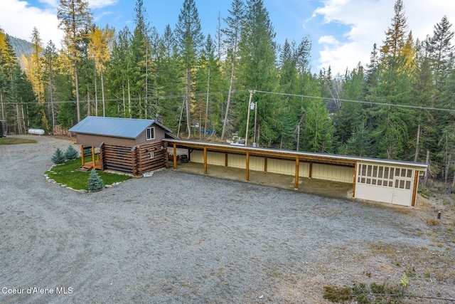 648 Curley Creek Rd, Moyie Springs, ID 83845 - log cabin featuring a view of trees, log siding, and metal roof