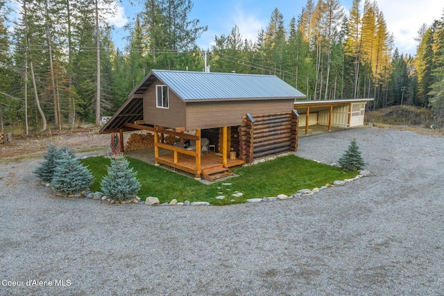 648 Curley Creek Rd, Moyie Springs, ID 83845 - view of side of home featuring metal roof, a view of trees, and log exterior
