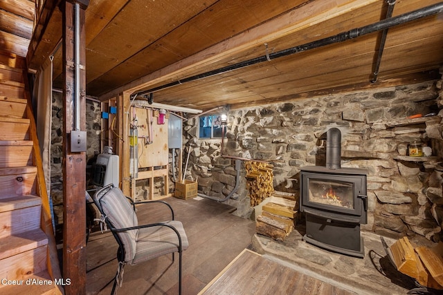 basement featuring hardwood / wood-style floors, a wood stove, and wooden ceiling