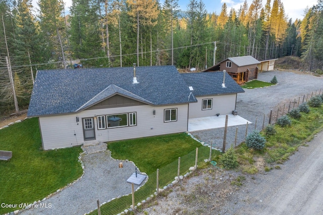 648 Curley Creek Rd, Moyie Springs, ID 83845 - rear view of house featuring a patio, roof with shingles, and a forest view