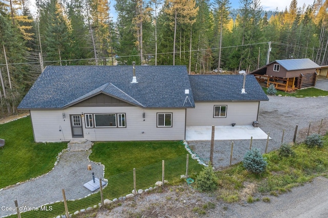 648 Curley Creek Rd, Moyie Springs, ID 83845 - back of property featuring a patio area, roof with shingles, and a forest view