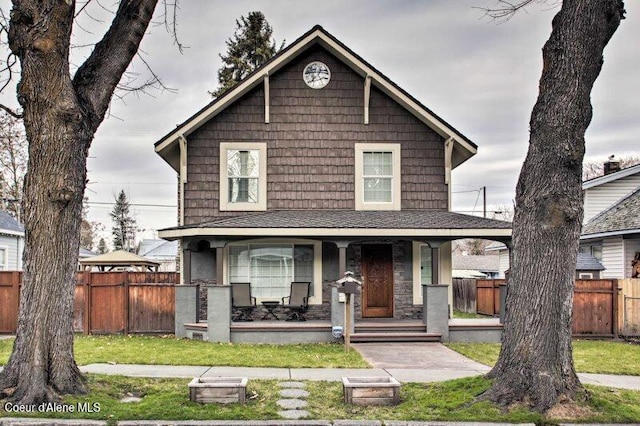 view of front of house with covered porch and a front lawn