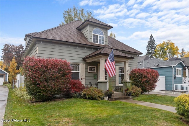 view of front of property with a front lawn and a shingled roof